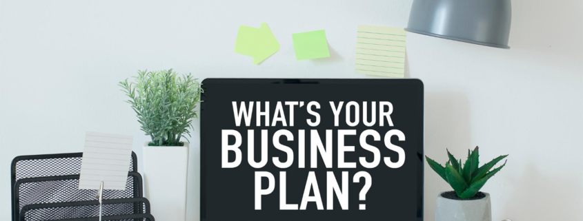 Laptop on a work desk with accessories against a white background