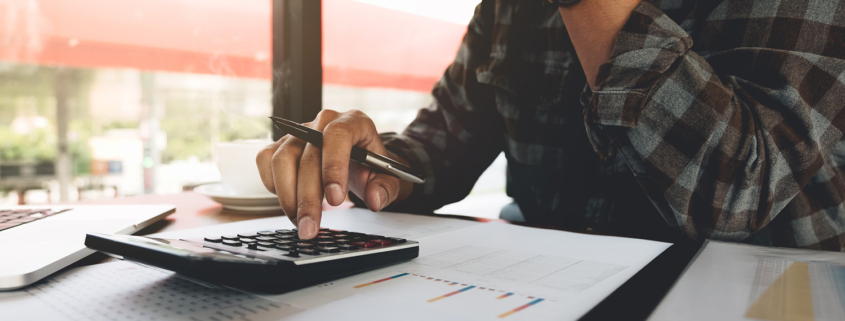 A man working about financial and analysis business document with calculator to calculating expenses, Accounting concept