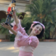 shot of a young ballerina playing Clara in a pink dress holding up a nutcracker